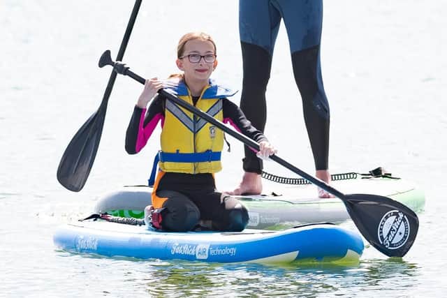 Olivia Picked on a paddle board with her instructor. Picture: Keith Woodland (110519-58)