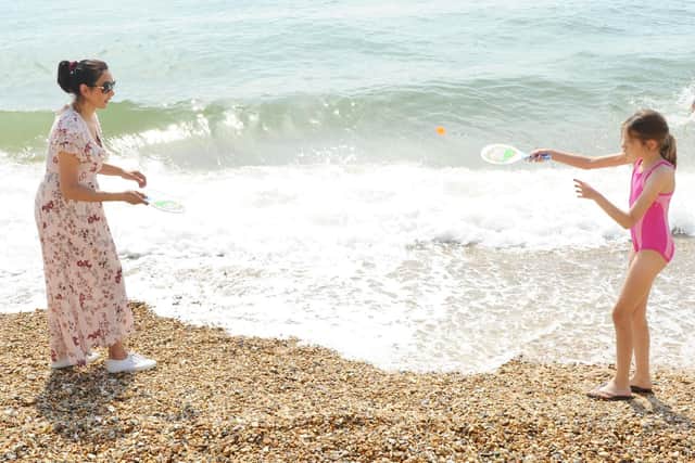 Warm weather is predicted for today. Pictured is: (left) Seraphine Malik from Surrey, playing bat and ball with her daughter Evelyn (9). Picture: Sarah Standing (190419-6333)