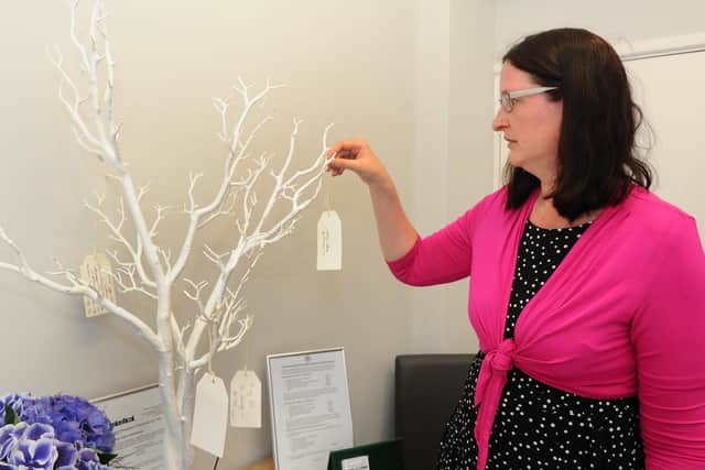 Funeral celebrant Chelsea Duke places a message on the memorial tree at Cutmore & Leadbetter Funeral Directors in Westbury Road, Fareham
Picture: Sarah Standing (240519-106)