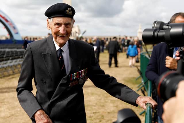 Former British Royal Marine, and D-Day veteran Jim Booth, reacts as he poses for a photograph