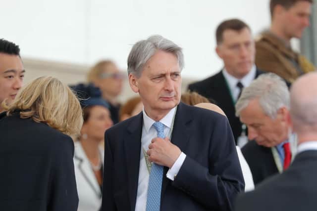 Britain's Chancellor of the Exchequer Philip Hammond (C)