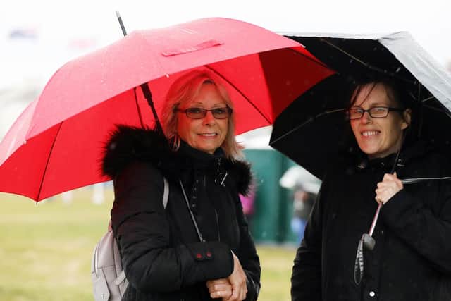 Wendy Carter, left, and Samantha Bray shelter under umbrellas.            
Picture: Chris Moorhouse