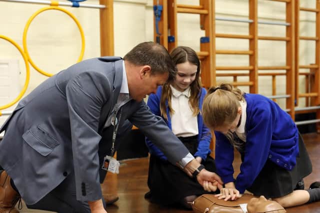 Headteacher Anthony Martin guides Leah Slevin, 11, and Sophie Smith, 10, right, as they practise resuscitation Picture: Chris Moorhouse           (120619-11)