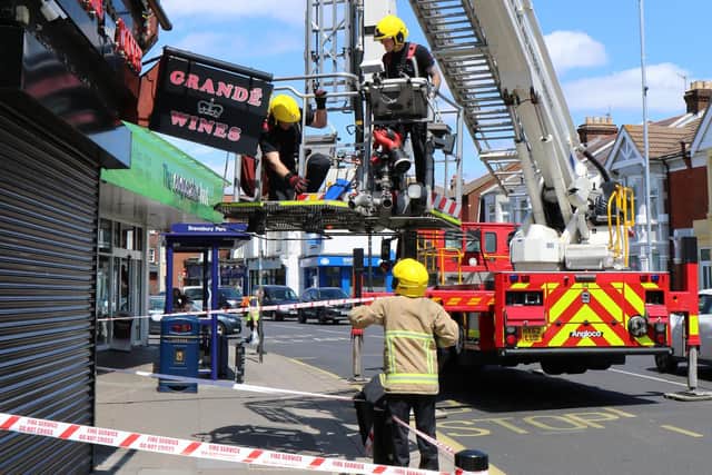 Firefighters cutting down the sign in Eastney Road. Picture: Phix-Pix Photo and Graphic Solutions