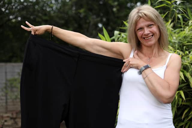 Trixi Ellis has lost 10 stone. She is pictured at home in Havant with a pair of trousers that used to be 'a bit tight'. Picture: Chris Moorhouse (120619-18)
