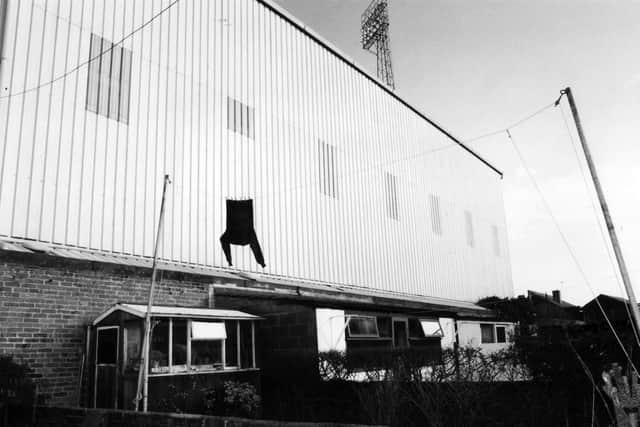 A lone shirt hangs to dry above a tiny back garden in Carisbrooke Road, behind the massive stands of Fratton Park. (0277-4)