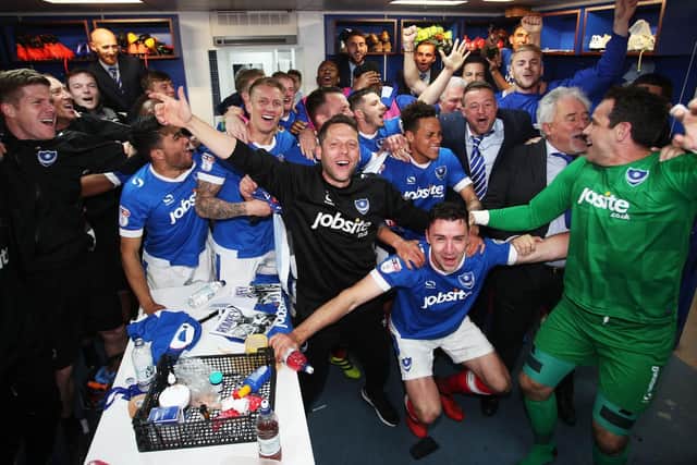 Pompey players, including Matt Clarke (back row) celebrate winning the League Two title after a dramatic final day 6-1 win over Cheltenham Town at Fratton Park on May 6, 2017.