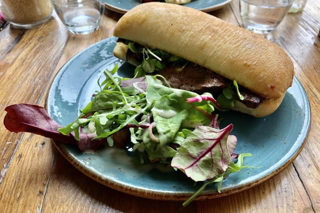 The steak sandwich, served with a side salad.