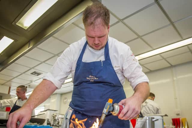 Ricky Farmer using a blow torch to cook some mangos. Picture: Habibur Rahman