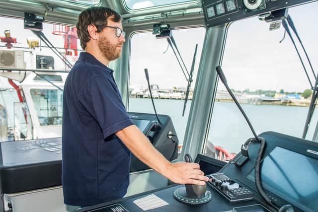 Skipper/ Tug master Lloyd Thompson operating the tug boat from the bridge.