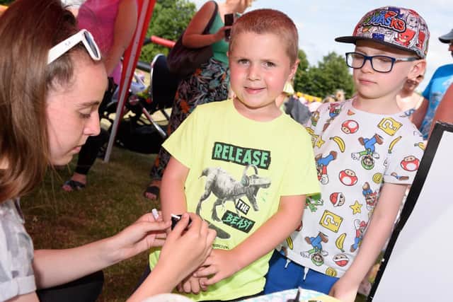 (L-R) Travis Davey (5yrs) and Cameron Moreno (6yrs) get glitter tattoos. Picture: Duncan Shepherd