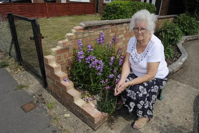 Edna Bennett surveys the damage to her garden wall in Leigh Park after it was hit by a delivery driver. Picture: Ian Hargreaves  (100719-1)