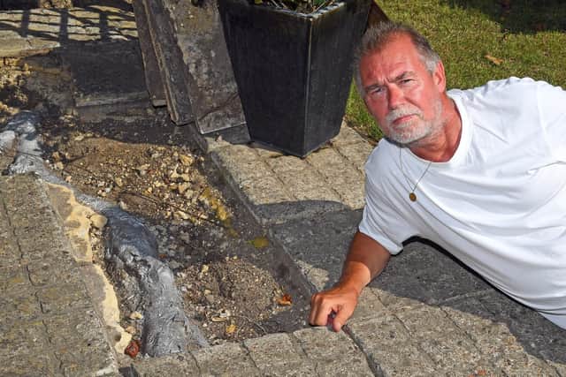Trevor Lock, 64, with the havoc-wreaking roots he says are owned by the council and damaging his home. He has painted them silver to highlight them. Picture: Malcolm Wells (190724-4790)