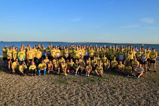 Members of Gosport Road Runners gather on the beach at Stokes Bay