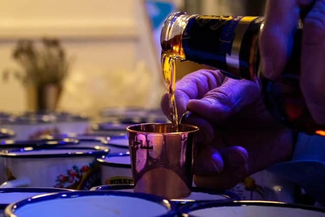 A shot of Pusser's Rum is poured on HMS Belfast as part of Black Tot Day. Photo: RNRMC