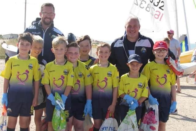 Big smiles as the Gosport Borough Blues under 10 squad clean up Stokes Bay beach to raise funds for new football kit