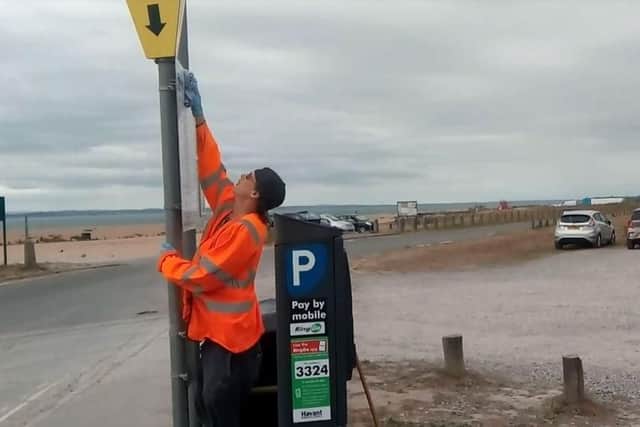 Workers cleaning the bins and signs at Beachlands at Hayling Island on September 3 after the beach lost its Blue Flag status. Picture: Neil Fatkin