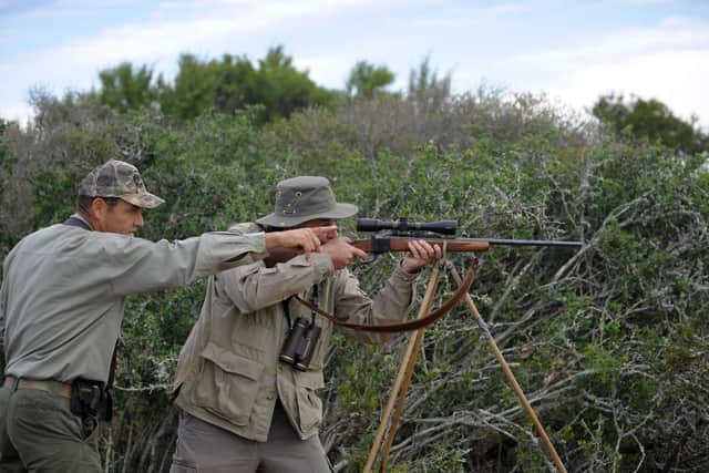 Philip Dixie (left), a professional hunter from Blaauwkrantz hunting reserve points out a trophy to man during a hunting Safari. Picture: Gianluigi Guercia / AFP / Getty Images