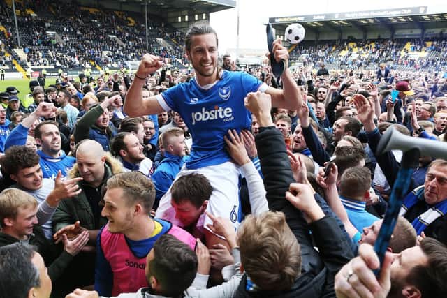 Christian Burgess is mobbed by Pompey fans after helping secure promotion at Notts County. Picture: Joe Pepler