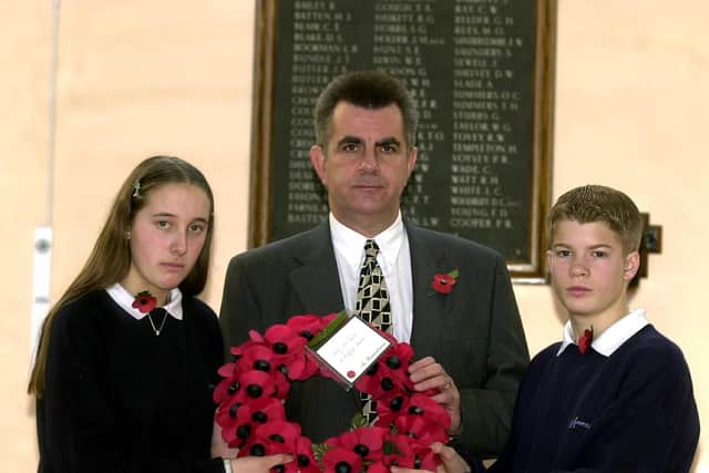 Head teacher Ian Cox with pupils Loise Crawford and Sam Rogers lay a wreath at the Mayfield School War Memorial.
