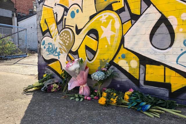 Flowers and cards left in memory of Lorraine Bream, who was found dead on a nearby rooftop on Monday.