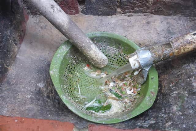 Photo shows a colander in an outside drain.