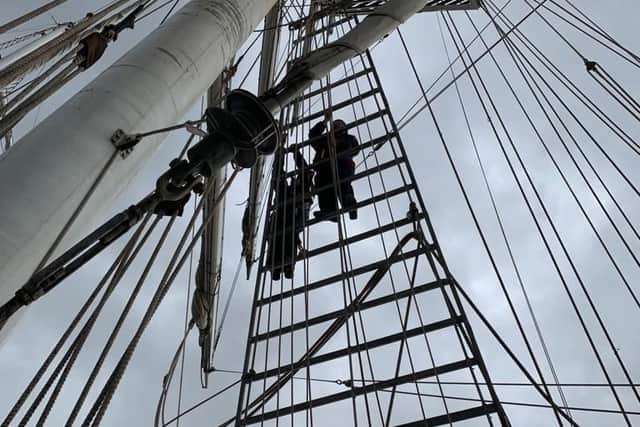 Cheryl Spencer climbing the rigging of the Lord Nelson.