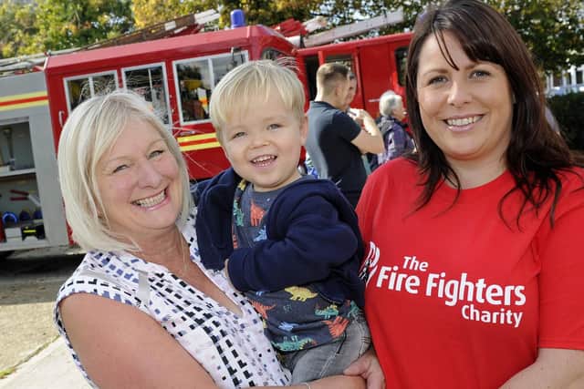 Portchester firefighters have staged a celebration at their station for recipients of money they collected from their Christmas fundraising events. (l to r), Christine Taylor with her grandson Ellis Treeby (two), and Kerry James of the Firefighters Charity. Picture: Ian Hargreaves  (061019-6)
