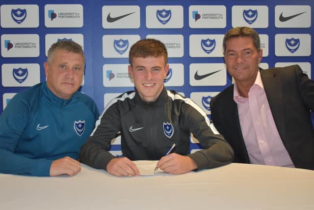 Harvey Rew signs his first professional deal at Pompey alongside academy boss Mark Kelly, left, and chief executive Mark Catlin, right. Picture: Portsmouth FC