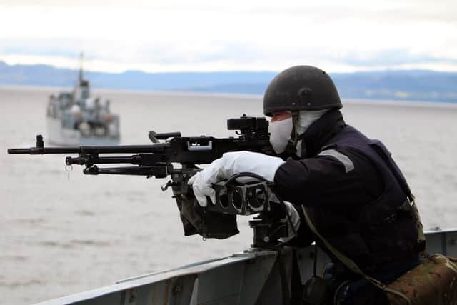 One of HMS Sutherland's gunners mans a General Purpose Machine Gun while minehunter HMS Hurworth manoeuvres ahead of the frigate. Picture: Royal Navy