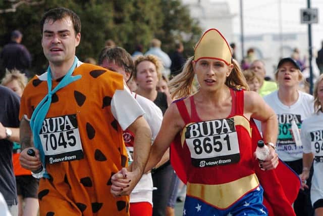 Barney and Superwoman costumed runners nearing the finishing line in the BUPA Great South Run 2004 event at Clarence Esplanade, Southsea. Picture: Michael Scaddan (044970-0665)