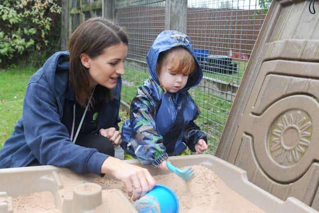 Sarah Hyndman, nursery practitioner, with Emily Penfold (3).

Picture: Sarah Standing (111019-8743)