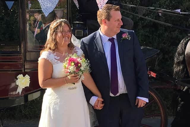 Sarah and Greg hold hands on their special day.