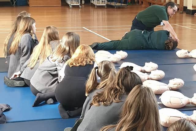 Children from The Cowplain School learn how to put a casualty into the recovery position.