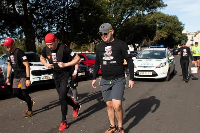 The police team pulling a police car around the course. (201019-293)