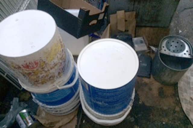 Food containers stored in rear yard on the floor and dirty cardboard