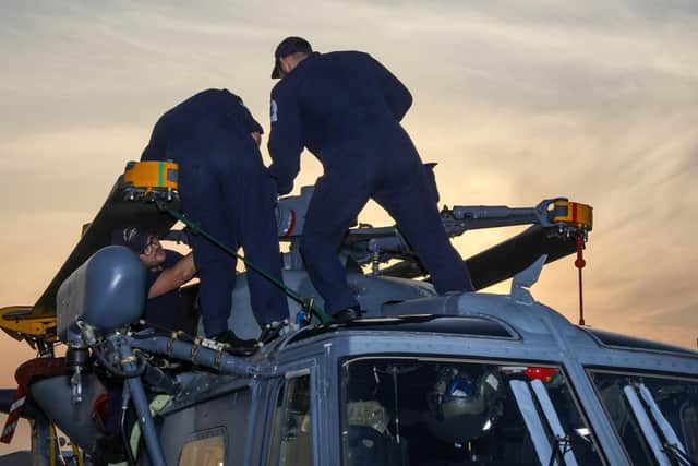 Crew from HMS Montrose work on the ships Merlin helicopter. Photo: LPhot Rory Arnold