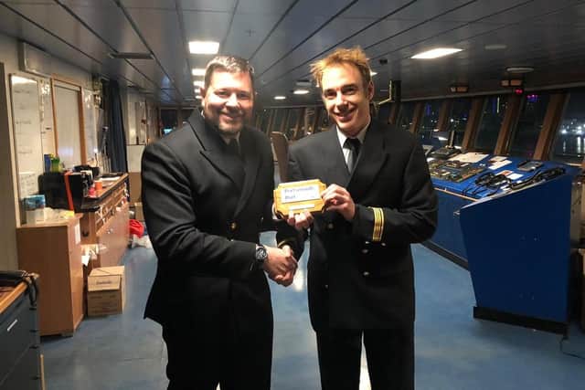 Harbour master Ben McInnes exchanges official plaques with the captain of the Connemara, Franois Le Breton, on the ships bridge.