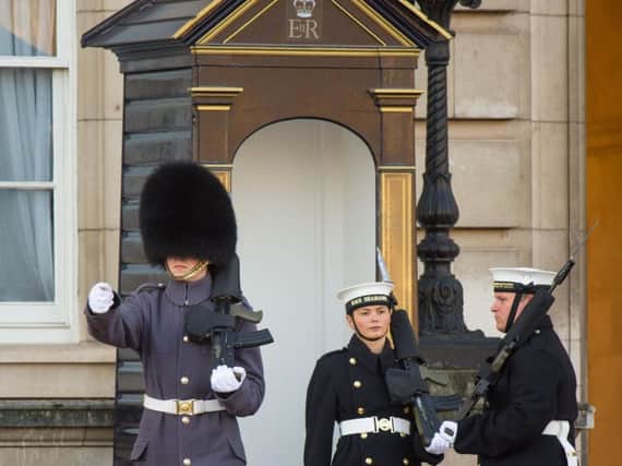 Able seaman Alex Stacey (centre) takes her position in a sentry box, as sailors from the Royal Navy perform the Changing of the Guard ceremony at Buckingham Palace, London, for the first time in its 357-year history. Picture: Dominic Lipinski/PA