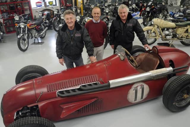 Martin Webb, right, and Ray Waller, left, of Comet Classics in Southbourne take possession of the Team Ant replica racing car from its builder Darren Collins, centre.Picture: Ian Hargreaves