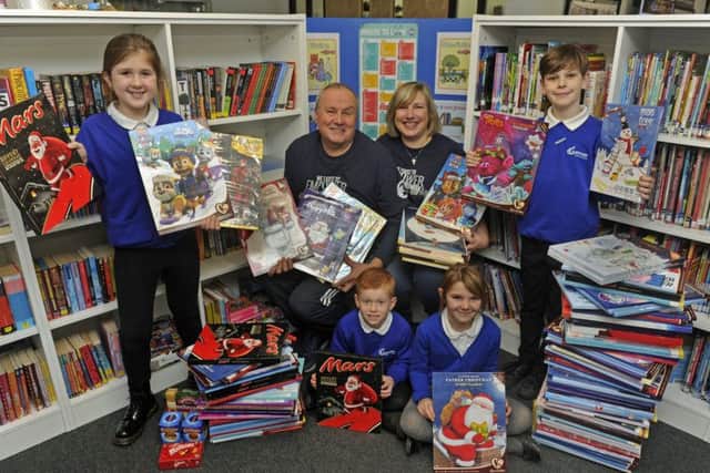 Pamela and Rob Hibbard from the Caring Hands charity collect the calendars from pupils (left to right), Suzy Ware (eight), Kai Rattley (seven), Heidi Cumming (seven), and Cody Bowers (nine)      Picture: Ian Hargreaves  (171581-1)