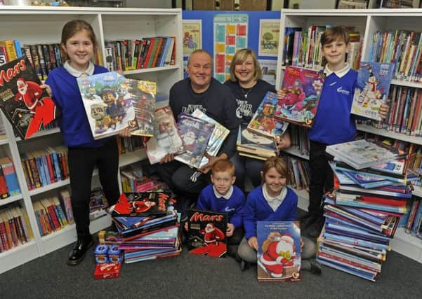Pamela and Rob Hibbard from the Caring Hands charity collect the calendars from pupils (left to right), Suzy Ware (eight), Kai Rattley (seven), Heidi Cumming (seven), and Cody Bowers (nine)      Picture: Ian Hargreaves  (171581-1)