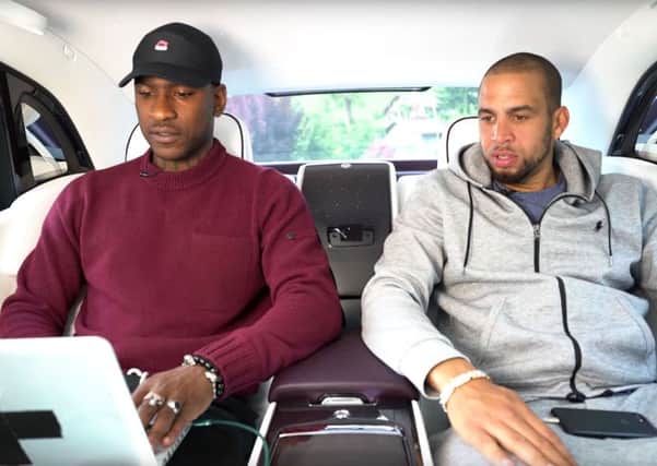 A screen grab  from the Rolls-Royce Motor Cars YouTube channel of a promotional video showing grime artist Skepta, left, and a friend being driven in a car while not wearing a seatbelts