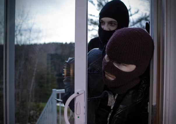 Two burglars entering a house through a patio door Picture posed by models