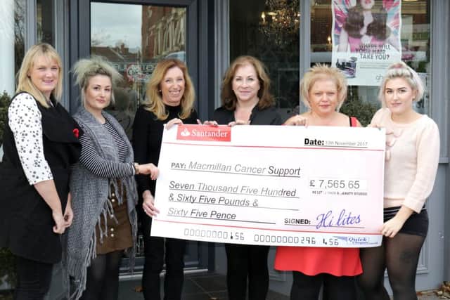 Members of staff from Hi-lites with the big cheque they are donating to charity after a year of fundraising