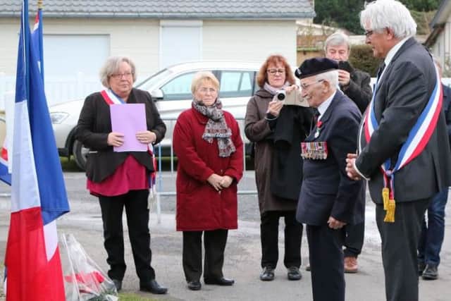 Veteran John Jenkins lays a wreath with local mayor Alain Scribe, far right, at Pioneers Street, Asnelles, close to where he landed in 1944