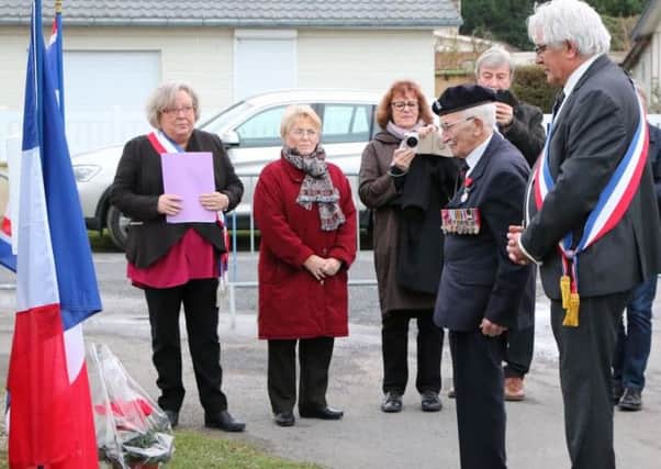 Veteran John Jenkins  lays a wreath with local mayor Alain Scribe, far right, at Pioneers Street,  Asnelles, close to where he landed in 1944