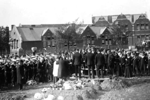 Chief Petty Officer Hebert Leas coffin is lowered into the grave. George Street School is in the distance.
