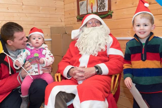Adam Westwood with Lily, 1, and Jacob, 3, and Father Christmas Picture: Keith Woodland