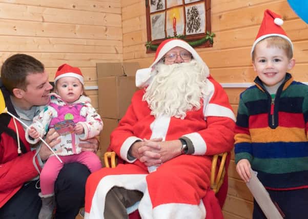 Adam Westwood with Lily, 1, and Jacob, 3, and Father Christmas   Picture: Keith Woodland